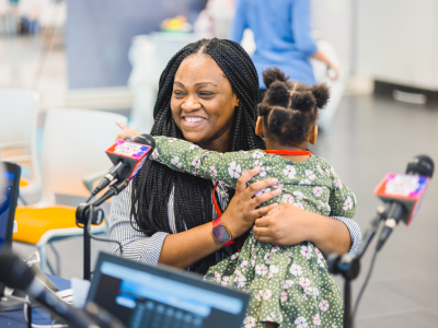 Jessica Carter of Jackson hugs daughter Lyndsey Lee Carter while talking with on-air personalities during the 2023 Mississippi Miracles Radiothon. 