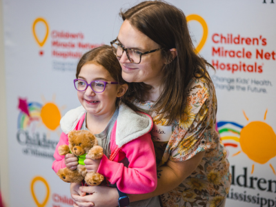 Children's of Mississippi patient Emma Porch of Brandon gets a hug from mom Melinda during the 2024 Mississippi Miracles Radiothon.