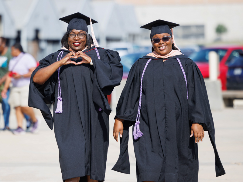 Masters of Science in Nursing recipients Ashley Andrews and Chekisha Tabb, left, celebrate outside the coliseum. Melanie Thortis/ UMMC Communications