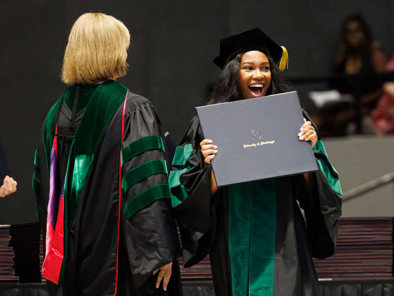 MD graduate Kayla Beamon beams upon receiving her degree from Dr. LouAnn Woodward, vice chancellor for health affairs and dean of the School of Medicine. Melanie Thortis/ UMMC Communications
