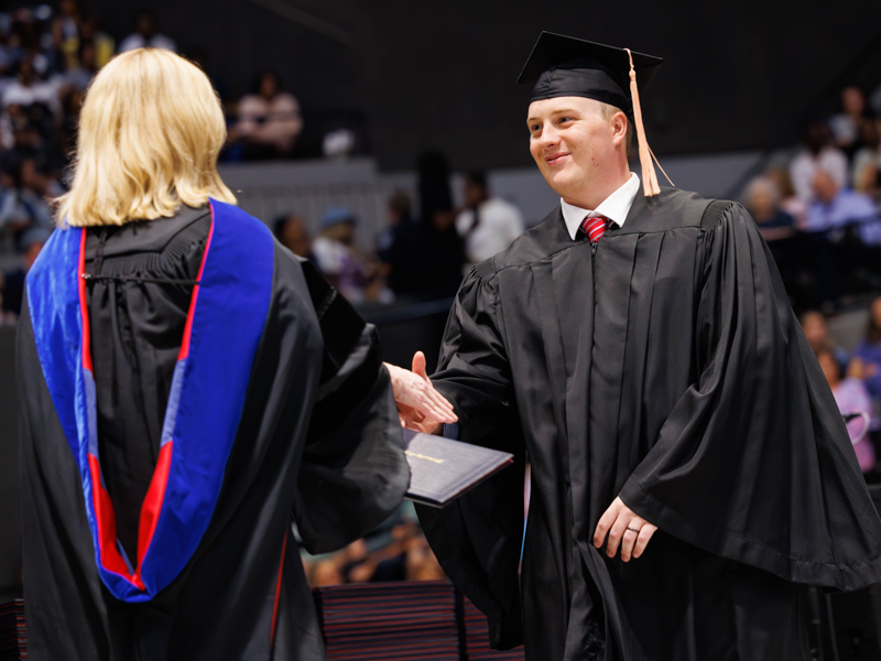 Alexander Dodson receives the BSN diploma from Dr. Tina Martin, dean of the School of Nursing. Melanie Thortis/ UMMC Communications