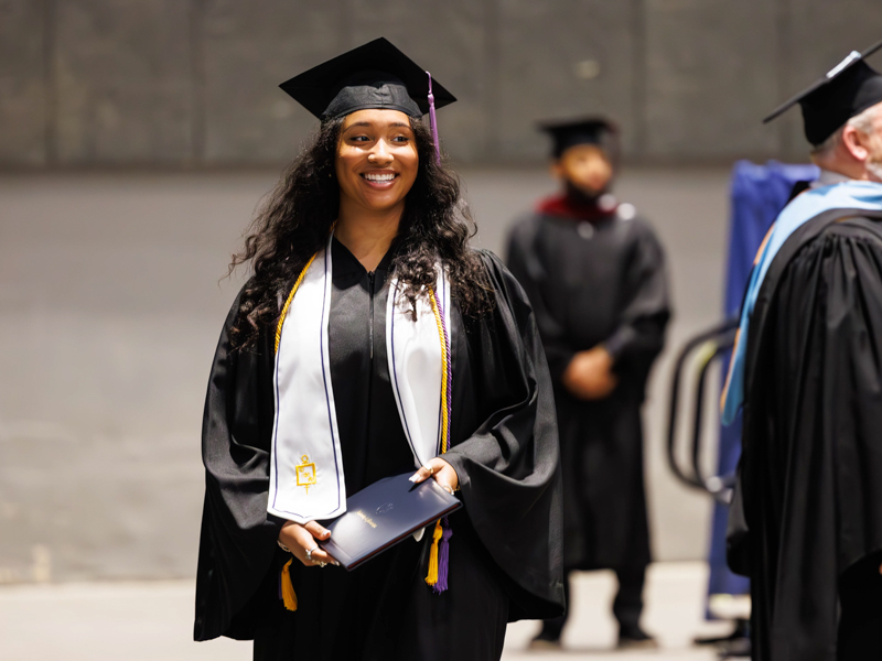 Hailey Manning exits the commencement stage with a Bachelor of Science in dental hygiene and a smile. Melanie Thortis/ UMMC Communications