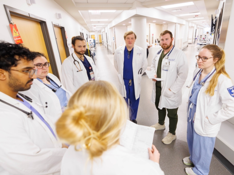 Asher, center, listens as his team, from left, Advait Praveen, medical student; Walker; Darian Raucher, medical student; Cole; Newbaker; and Bell complete rounds on 6 South.