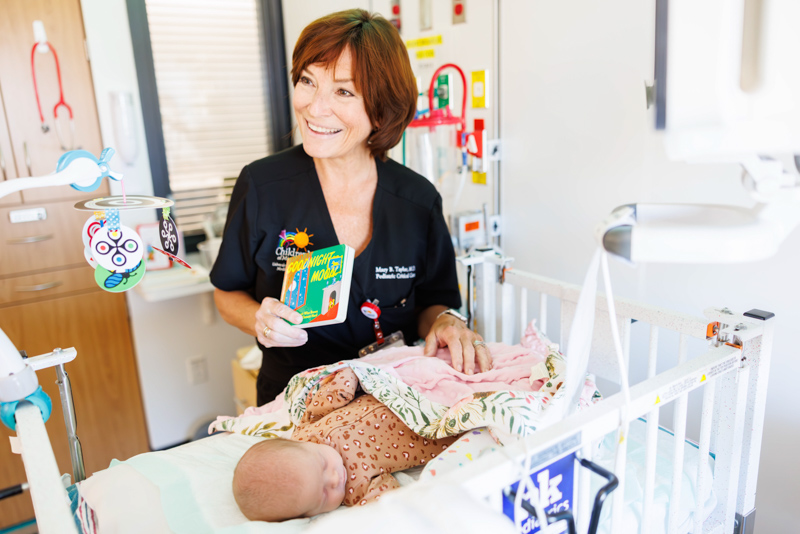 Dr. Mary Taylor, Suzan B. Thames Chair and professor of pediatrics, shows Children's of Mississippi patient Bailey Engram's copy of "Good Night Moon.