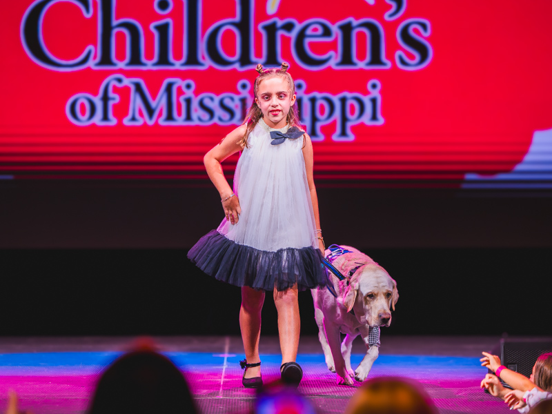 Emma Eubank and service dog Clyde model during the Peppermint Prance Tween Fashion Show at Mistletoe Marketplace.