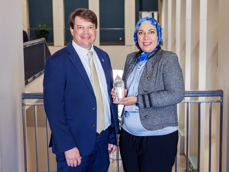 Dr. Lee Bidwell, associate vice chancellor for research, presents the Early Career Investigator Award to Dr. Noha Elsayed, assistant professor of pharmacology and toxicology.
