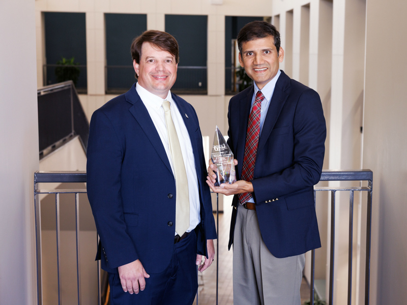 Dr. Lee Bidwell, left, associate vice chancellor for research, presents the Richard L. Summers Outstanding Achievement in Clinical Research to Dr. Vinayak K. Nahar, associate professor of dermatology.