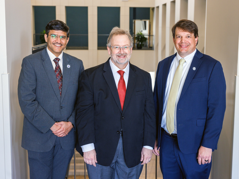 Dr. Lee Bidwell, right, associate vice chancellor for research, congratulates, from left, Dr. Amol Janorkar, chair of biomedical materials science in the School of Dentistry, and Dr. James Rowlett, professor of psychiatry, on their patents.
