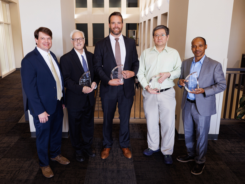 Dr. Lee Bidwell, left, associate vice chancellor for research, congratulates Translational Research Team Award winners, from left, Dr. William B. Hillegass, professor of research; Dr. Seth T. Lirette, associate professor of research; Dr. Yufeng Zheng, PhD, associate professor of research; and Dr. Wondwosen K. Yimer, associate professor of research, all of the Department of Data Science.