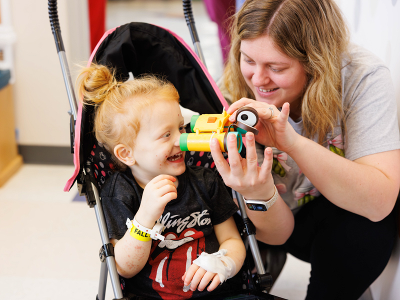 Bailynn Phillips, 2, of Vicksburg, plays with toy brought by MSU basketball player Josh Hubbard. Melanie Thortis/ UMMC Communications