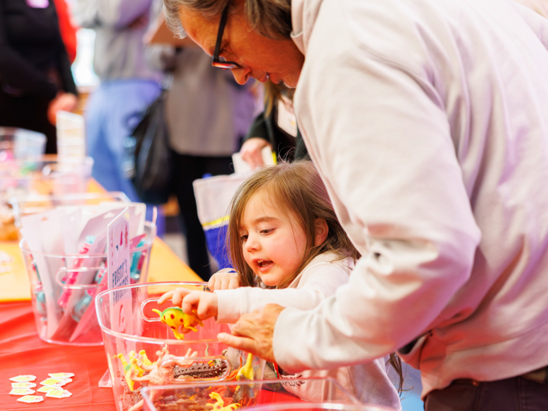 Vivian Ross, 4, of Pass Christian, chooses a dinosaur to add to her stocking at Santa's Workshop. Melanie Thortis/ UMMC Communications
