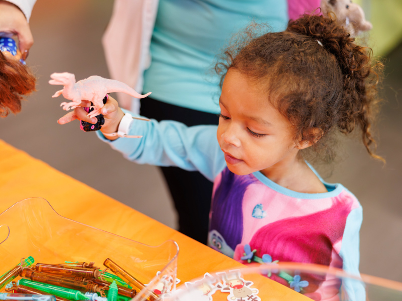 Carmyn English, 3, of Terry chooses a dinosaur to put into her stocking at Santa's Workshop. Melanie Thortis/ UMMC Communications