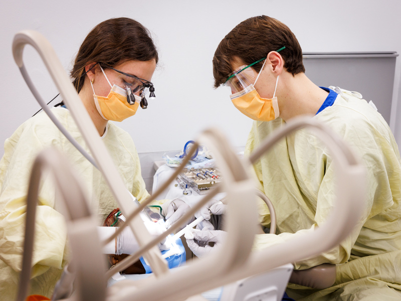 Dental students Avery Gibens and Jolan Mills perform root canal on Tenika Spann of Jackson during the 10th annual Dental Mission Week.