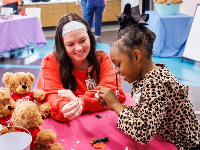 Abigail Tolliver, 8, of Magnolia, works with Child Life intern, Abbey Harper, on a love bug valentine. Jay Ferchaud/ UMMC Communications