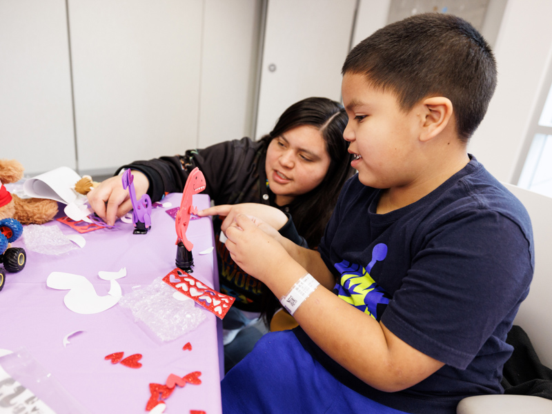 Ezias Bell, 7, of Choctaw, decorates his dinosaur valentine at the Friends of Children's Valentine's Day event. Jay Ferchaud/ UMMC Communications 
