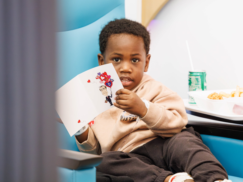 Kaeson Boler, 3, of Louisville checks out his valentine given by Lt Governor Delbert Hosemann. Melanie Thortis/ UMMC Communications