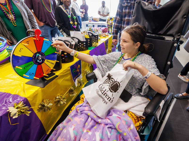 Hollie Jackson, 11, of Silver Creek spins the wheel to win a prize at the Children's of Mississippi Mardis Gras parade. Jay Ferchaud/ UMMC Communications