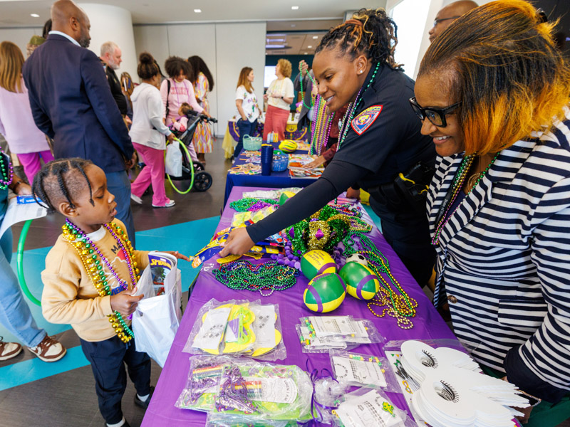 Jayden Tatum, 6, of Columbia receives a toy prize from Corp. Shartavia Colemen, center, and Andreana Smith, Mississippi DPS transportation enforcement. Jay Ferchaud/ UMMC Communications 