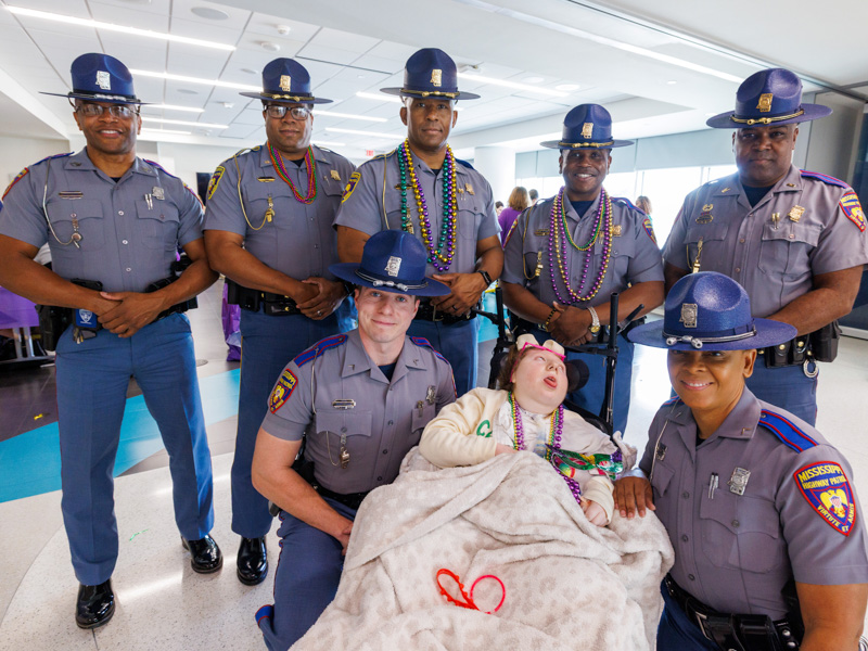 Cali McCleave, 11, of Clinton poses with Mississippi Highway Patrol Officers. Jay Ferchaud/ UMMC Communications
