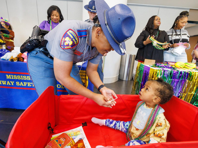 Kristen Sandifer, 1, of Magee receives a toy from Trooper First Class Darnika Mayfield. Jay Ferchaud/ UMMC Communications