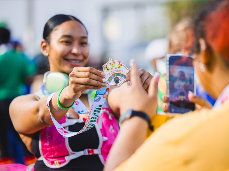 Hannah Lee of Jackson shows off the 2026 Run the Rainbow half marathon medal after finishing her race.