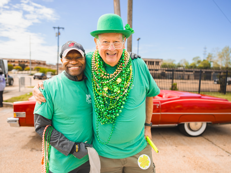 L.A. Warren, communications specialist at UMMC hands out beads with Cole Smith, Mayor of Children's, at City Sweep benefitting the children's hospital. Lindsay McMurtray/ UMMC Communications