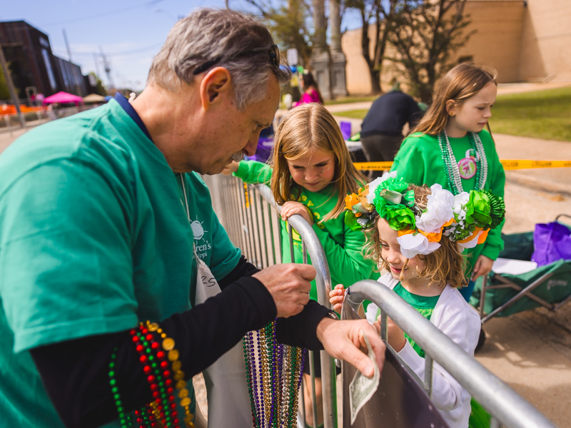 Brad Ewing, director-development schools at UMMC, lets Magnolia Parkinson choose what color beads she wears at City Sweep benefitting the children's hospital. Lindsay McMurtray/ UMMC Communications