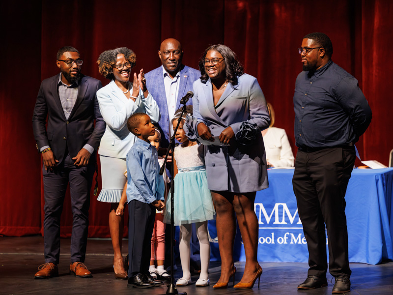 Deshauntra Green-Johnson is flanked by her brother Dontrell Green, her mother Guy Green, her father Hugh Green and her husband Krystian Johnson as she announces her matching in obstetrics & gynecology at UMMC during the School of Medicine Match Day ceremony.