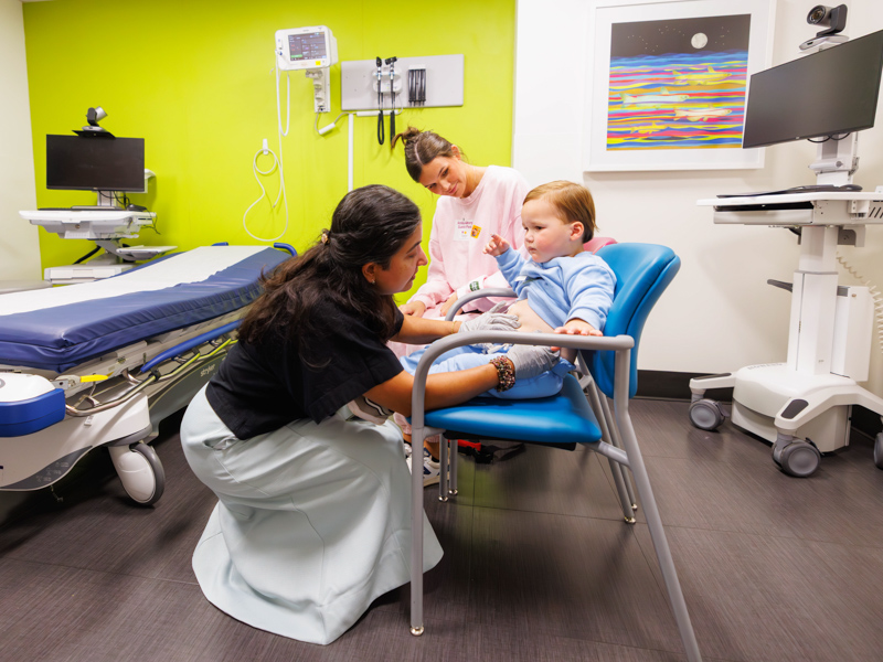 Bain Brandon, 2, shows Dr. Anju Sukumaran, pediatric endocrinologist, his insulin pump sites during his appointment at the children's hospital.