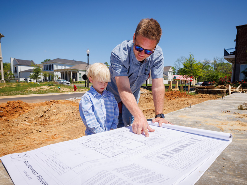 Decker and his son, John Walker, looking at blueprints for The Village of Madison.