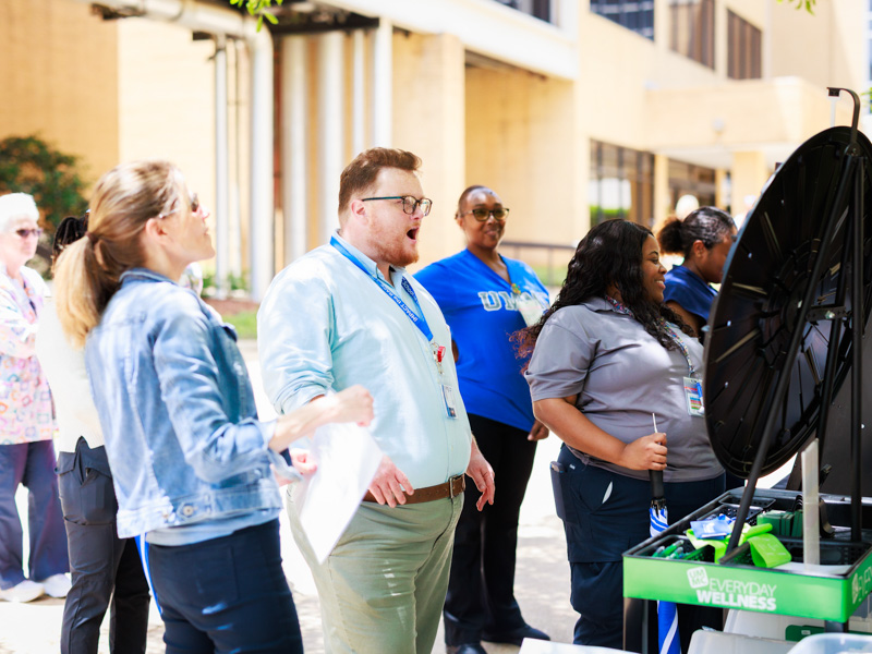 Dakota Bibbs, medical student advising director, spins the prize wheel at the Office of Well-being's mini carnival during Employee Appreciation Week 2025.