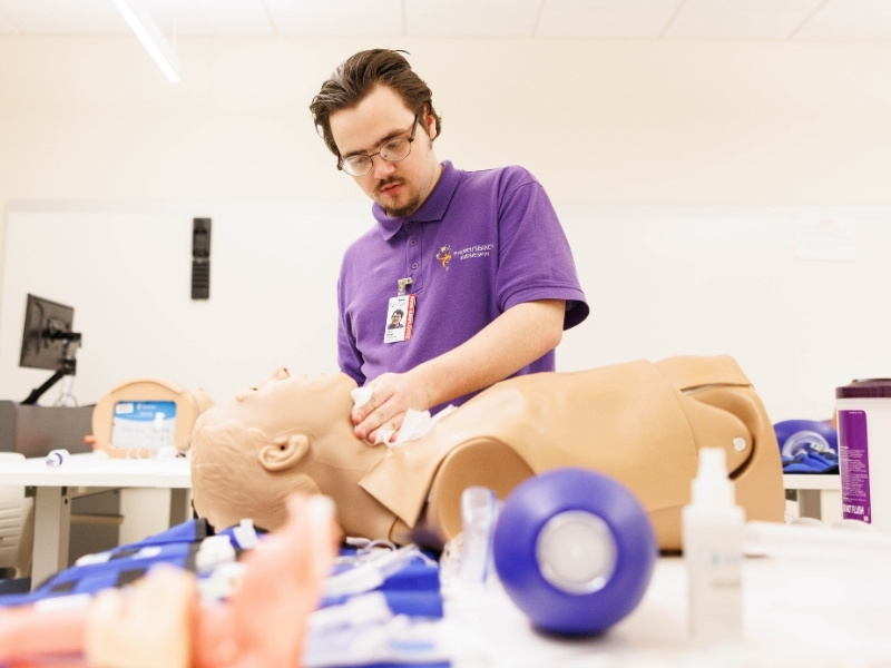 Dylan Morgan sanitzes CPR dummies in the Life Support Training Center as part of his Project Search internship.