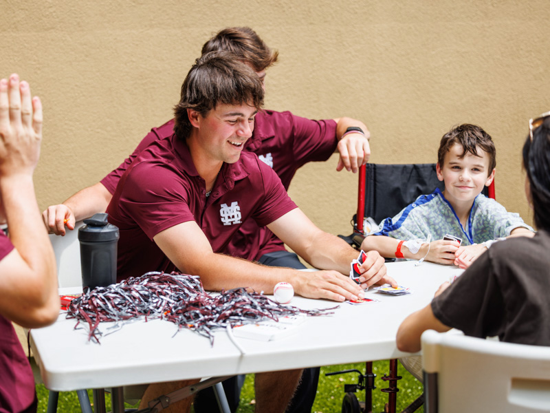 Mississippi State baseball player Braden Booth plays uno with Brantley Borne, 10, of Brookhaven.