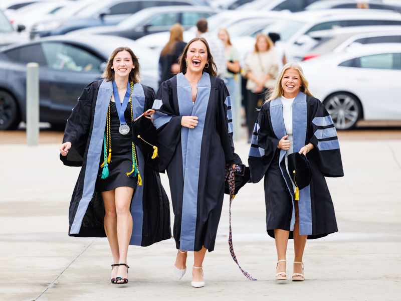 Occupational therapy PhD graduates beam with excitement. They are, from left, Alex Wolfe, Maci Kirkland and Bailey Somerville.