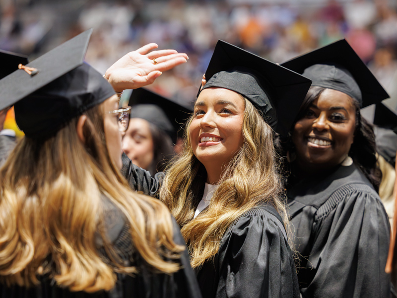 Anna-Maria Gaines finds a friendly face in the crowd shortly before receiving her BSN.