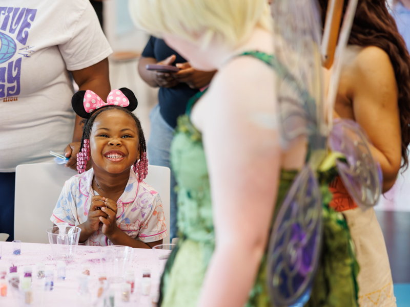 Tzuri Elmore, 5, of Greenville makes pixie dust with Tinkerbell at Disney Day hosted in the Sanderson Tower Community Room.