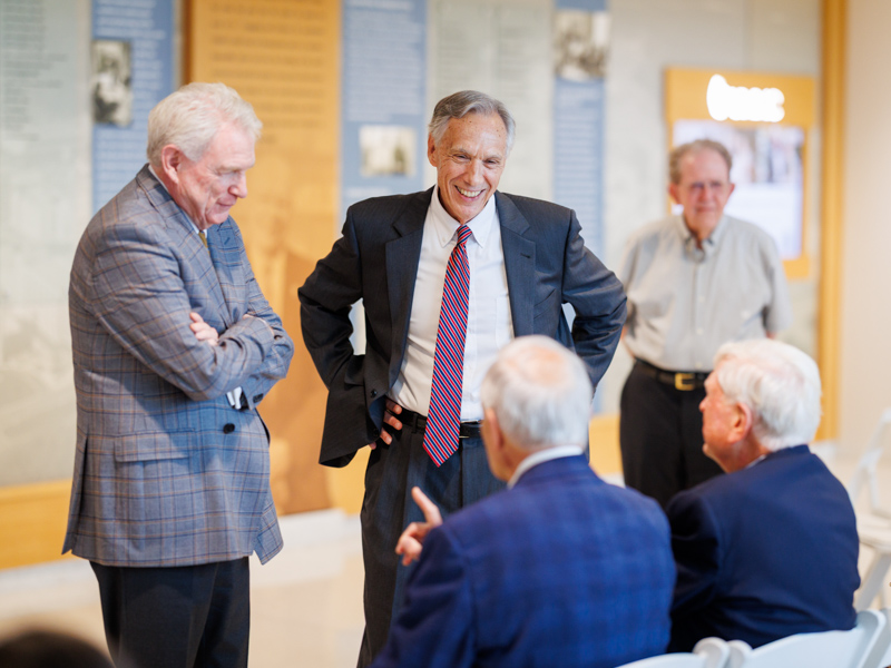 Dr. Dan Jones, left, and Dr. John E. Hall share a lighthearted moment with friends and colleagues before the start of the retirement celebration. Joe Ellis/ UMMC Communications