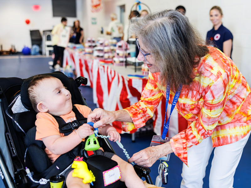 Junior Lovette, 1, reunites with Dr. Mary Kosek, professor of pediatric neonatology, during the NICU reunion at the children's hospital.
