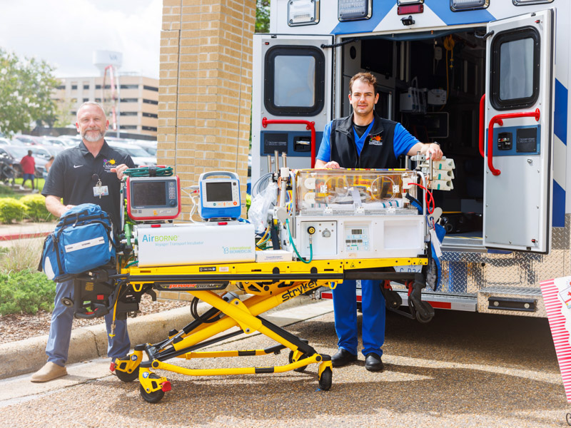 Wesley Smith, chief nursing officer, and Stephen Wray, Children's critical care transport RN, greet patients entering the student union for the NICU reunion.