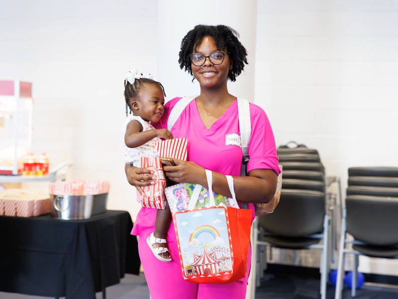 Jentri Stewart, 1, and her mother, Shay Odems, enjoy some popcorn during the NICU Reunion at the children's hospital.
