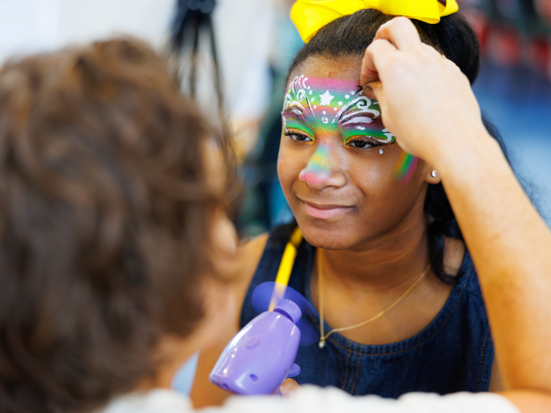 Former NICU patient Morgan Adams, 11, gets her face painted during the carnival-themed NICU reunion at the children's hospital.