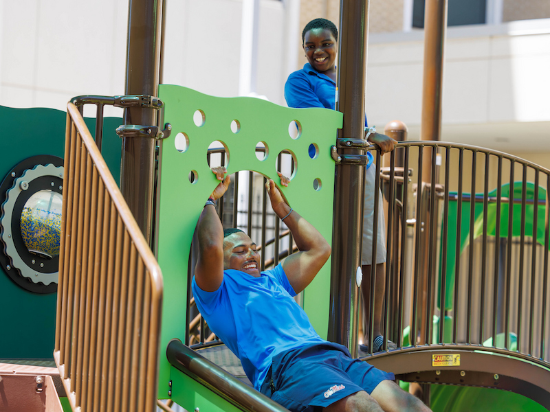Ole Miss running back Joshua Dye spends some time with Montay Brown, 11, of Meridian during the University of Mississippi football team visit to the children's hospital.