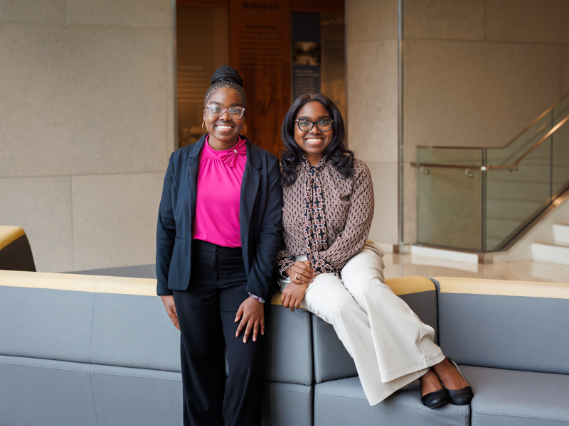Twins Nyla and Nyja Wilson pose in the entryway of the School of Medicine during their first week in the P.R.O.M.I.S.E. Program, marking the beginning of their hands-on experience and academic exploration in medicine. Joe Ellis/ UMMC Communications