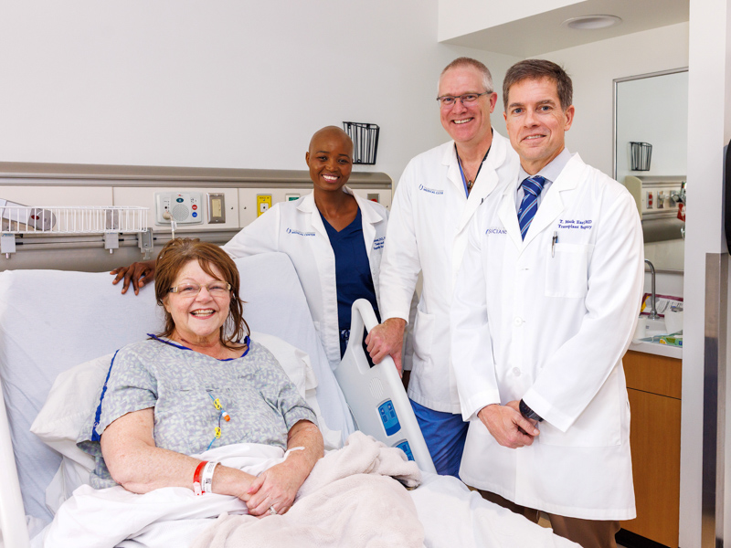 Ashley Castle smiles with her transplant team, from left, Dr. Praise Matemavi, Dr. Chris Anderson and Dr. Mark Earl.