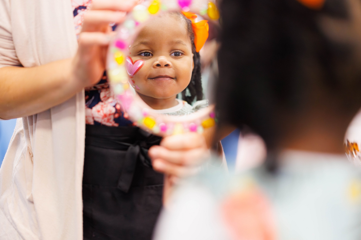 Samantha Boyd, 2, of Jackson inspects her pink heart face paint at Fair with Friends.