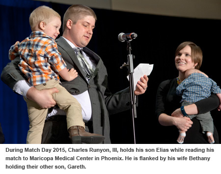 During Match Day 2015, Charles Runyon, III, holds his son Elias while reading his match to Maricopa Medical Center in Phoenix. He is flanked by his wife Bethany holding their other son, Gareth.
