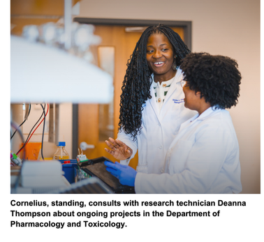 Cornelius, standing, consults with research technician Deanna Thompson about ongoing projects in the Department of Pharmacology and Toxicology.
