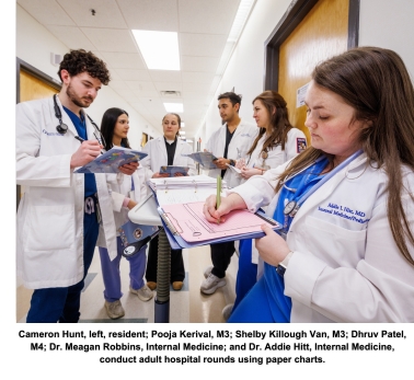 Cameron Hunt, left, resident; Pooja Kerival, M3; Shelby Killough Van, M3; Dhruv Patel, M4; Dr. Meagan Robbins, Internal Medicine; and Dr. Addie Hitt, Internal Medicine, conduct adult hospital rounds using paper charts.