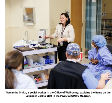 Samantha Smith, a social worker in the Office of Well-being, explains the items on the Lavender Cart to staff in the PACU at UMMC Madison.