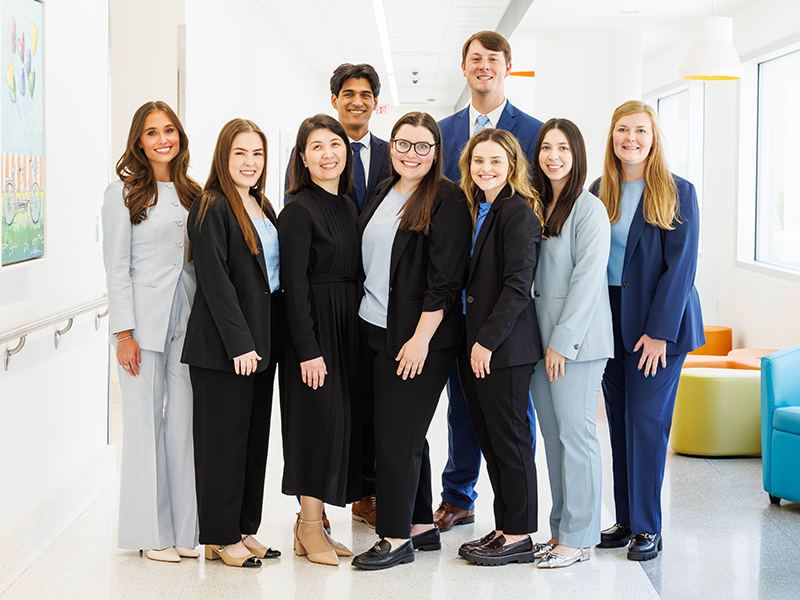 A group of nine UMMC-based pharmacy residents pose in Sanderson Tower.